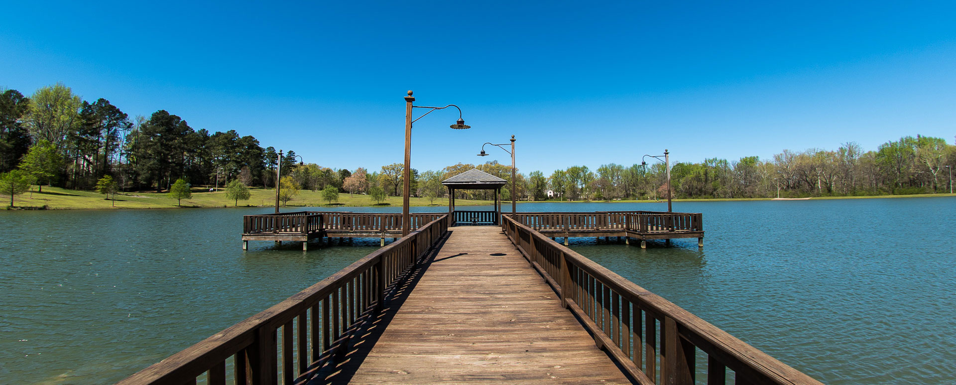 The dock leading out to the middle of the pond at Lamar Park