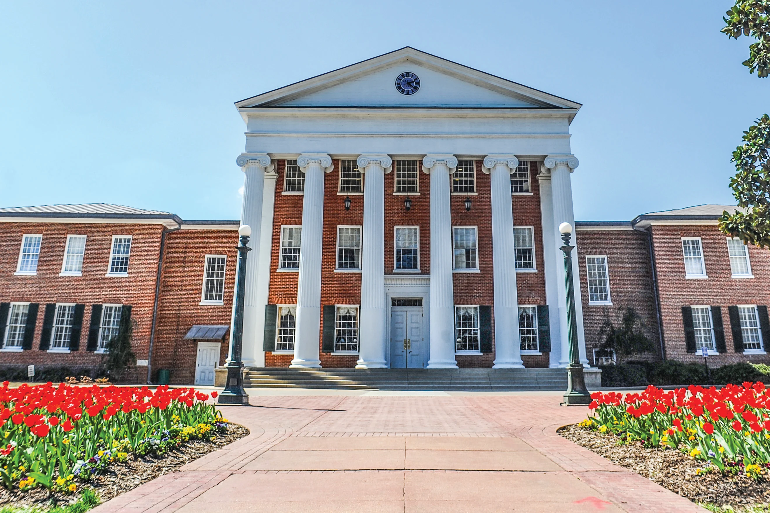 An image of one of the buildings at Ole Miss with red tulips in front